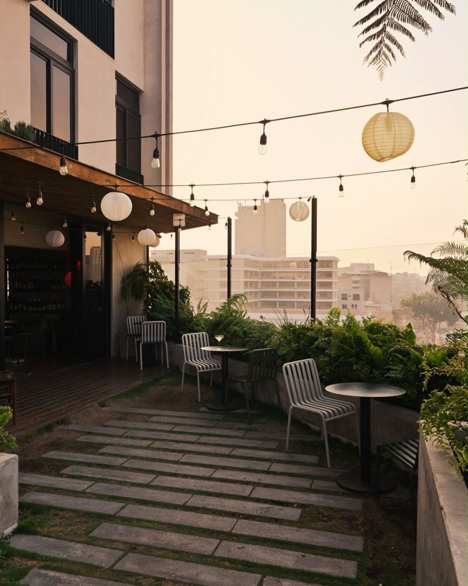 La terraza de Bacán al atardecer, con faroles de papel, plantas y vista a la ciudad